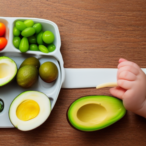 An image of a baby happily eating a piece of ripe avocado with their hands, surrounded by other healthy foods such as steamed vegetables, boiled eggs, and fruits.